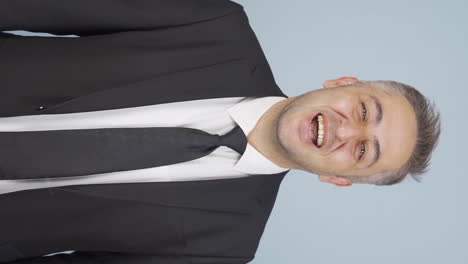 Vertical-video-of-Businessman-laughing-at-camera.